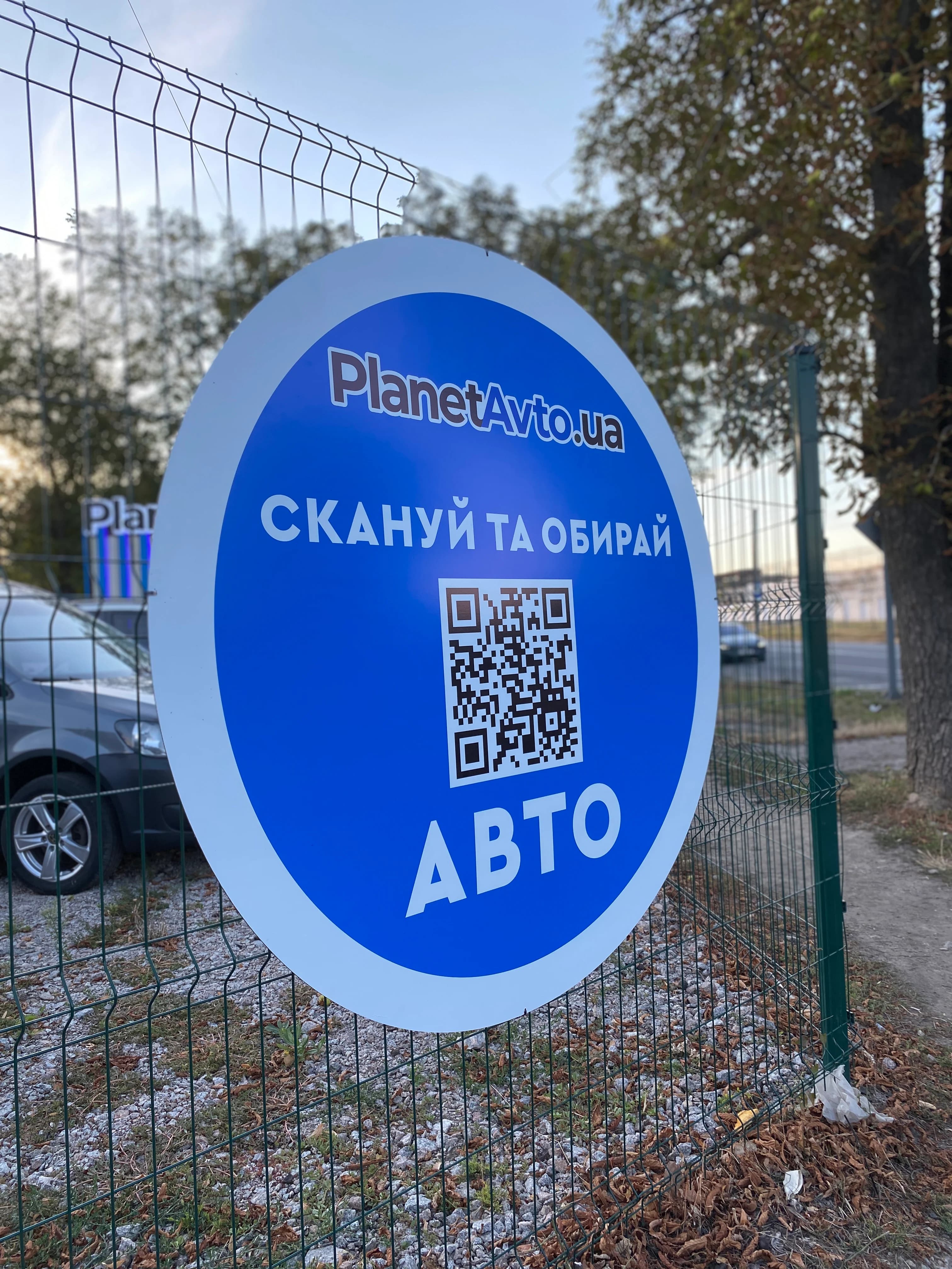 Кругла навігаційна табличка PlanetAvto з QR-кодом біля автоточки