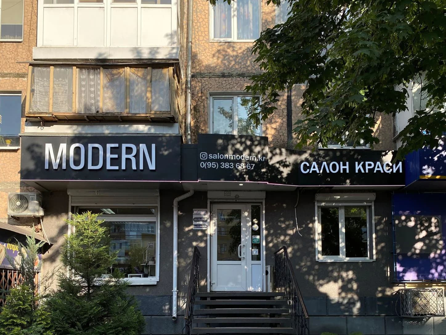 Загальний план фасаду салону краси MODERN із вивіскою та входом