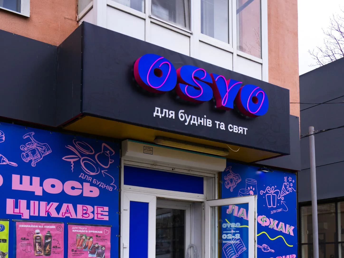Фасад магазину OSYO з об’ємною вивіскою над входом і синім банерним оформленням